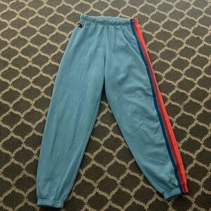 Aviator Nation neon blue sweatpants with 5 neon rainbow stripes